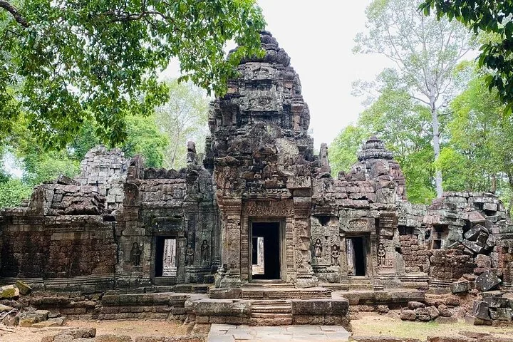 Een rijk versierde oude stenen tempel omringd door bomen in de jungle.